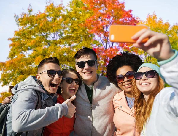 Friends taking selfie by smartphone in autumn park — Stock Photo, Image