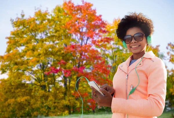 Jovem feliz com smartphone e fones de ouvido — Fotografia de Stock