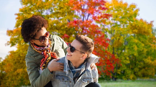 Happy teenage couple having fun in autumn park — Stock Photo, Image