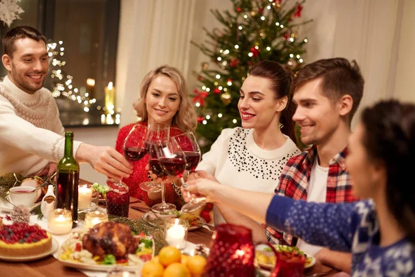 Amigos celebrando la Navidad y bebiendo vino —  Fotos de Stock