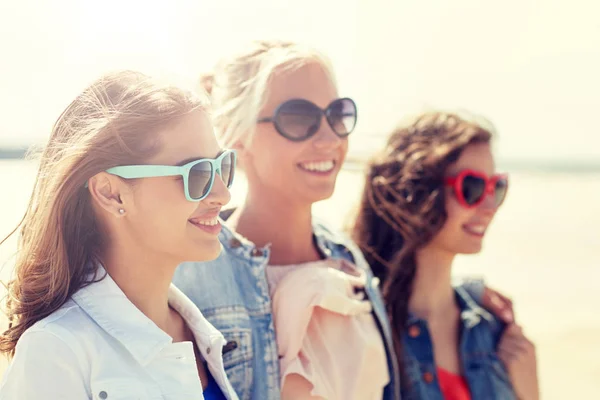Grupo de mulheres sorridentes em óculos de sol na praia — Fotografia de Stock