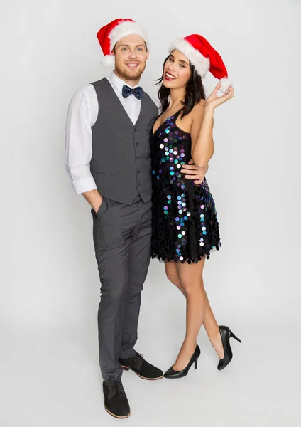 幸せなカップルのクリスマス パーティーでサンタ帽子 — ストック写真