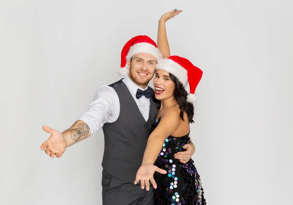 Feliz casal em santa chapéus na festa de Natal — Fotografia de Stock