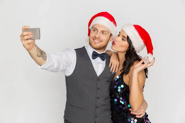Coppia in cappelli di Babbo Natale facendo selfie a Natale — Foto Stock