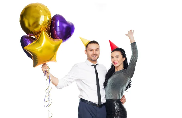 Couple heureux avec casquettes de fête et ballons — Photo