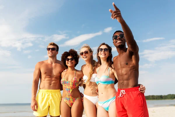 Amigos felices abrazándose en la playa de verano — Foto de Stock