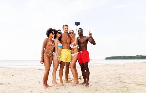 Szczęśliwy przyjaciele biorąc selfie na letniej plaży — Zdjęcie stockowe