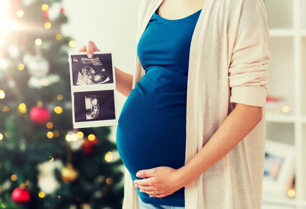 Pregnant woman with ultrasound images at christmas — Stock Photo, Image