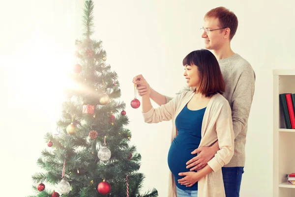 Feliz esposa grávida e marido na árvore de Natal — Fotografia de Stock
