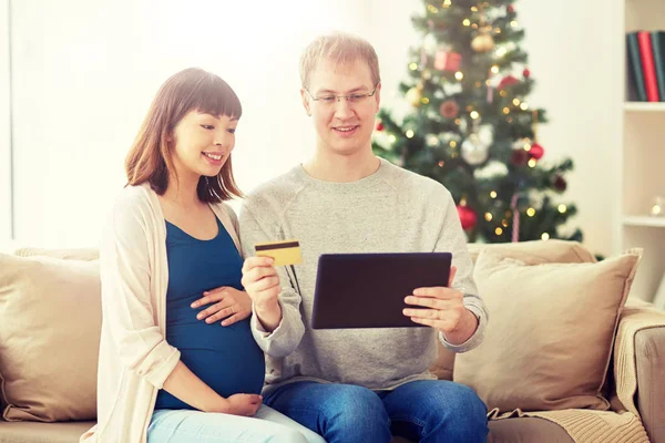 Mann und schwangere Frau kaufen zu Weihnachten online ein — Stockfoto