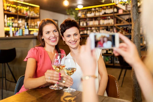 Mulher imaginando amigos por smartphone no bar de vinhos — Fotografia de Stock