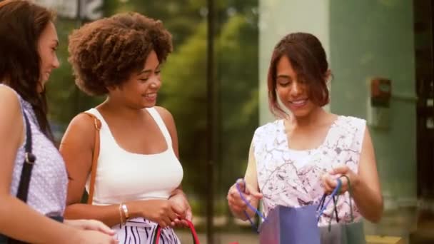 Femmes heureuses montrant des sacs à provisions en ville — Video