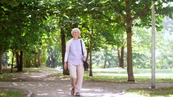Ευτυχής ανώτερος γυναίκα περπατώντας καλοκαίρι πάρκο — Αρχείο Βίντεο