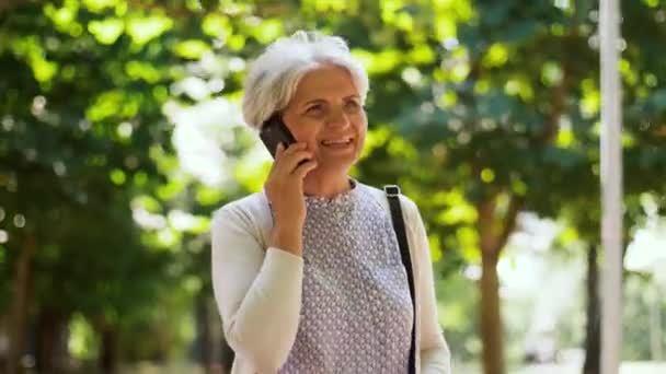Senior femme appelant sur smartphone dans le parc — Video