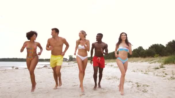 Šťastní přátelé běží na letní pláži — Stock video