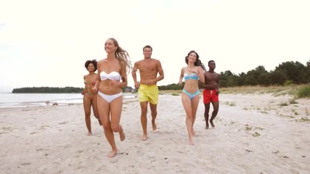 Amigos felices corriendo en la playa de verano — Vídeo de stock