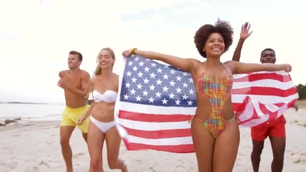 Φίλοι με αμερικανική σημαία που τρέχει στην παραλία το καλοκαίρι — Αρχείο Βίντεο