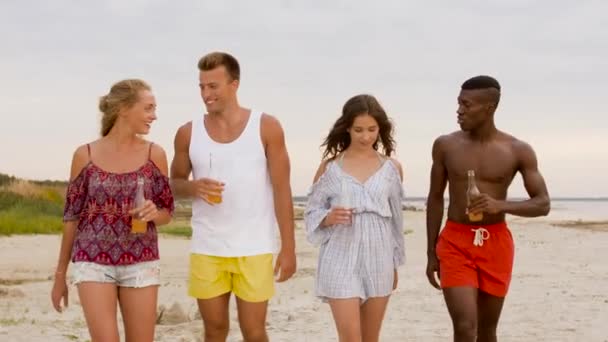 Vrienden met alcoholvrije dranken wandelen op strand — Stockvideo