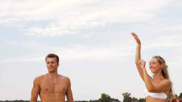 Happy vrienden spelen bal op zomer-strand — Stockvideo