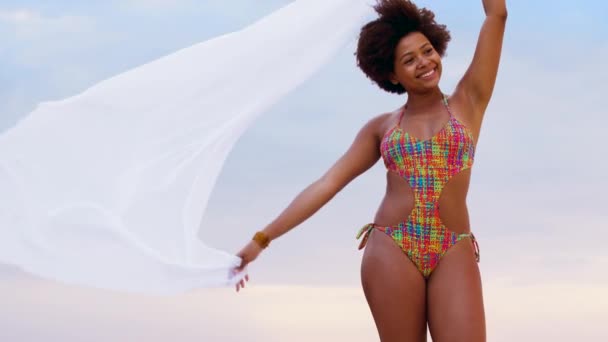 Mujer africana con chal ondeando en el viento en la playa — Vídeos de Stock