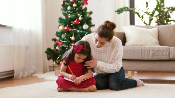 Mãe e filha com caderno no Natal — Vídeo de Stock