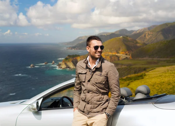 Man at convertible car over big sur hills — Stock Photo, Image