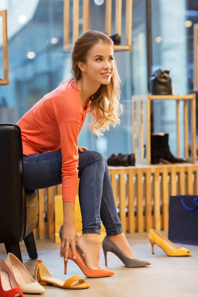 Mujer joven probando zapatos de tacón alto en la tienda —  Fotos de Stock