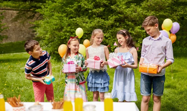 Glückliche Kinder mit Geschenken auf Geburtstagsparty im Sommer — Stockfoto