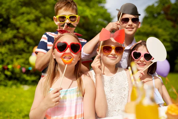 Niños felices con accesorios de fiesta en el cumpleaños en verano —  Fotos de Stock