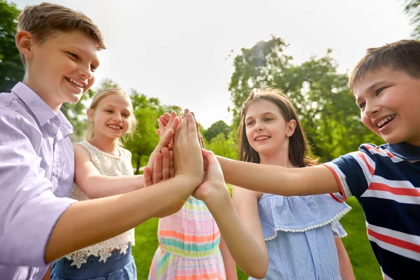 Groep gelukkige kinderen maken hoog vijf buitenshuis — Stockfoto