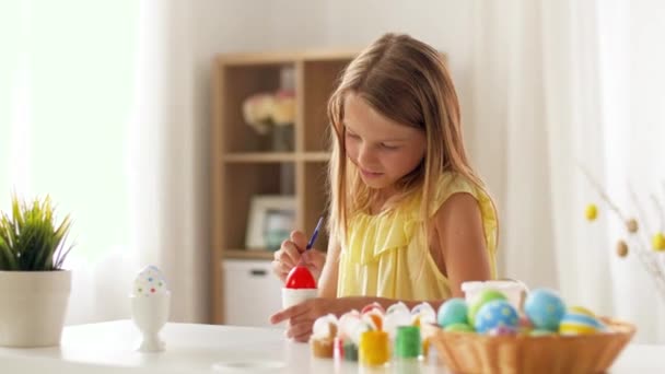 Ευτυχισμένος κορίτσι χρωματισμός αυγά του Πάσχα στο σπίτι — Αρχείο Βίντεο