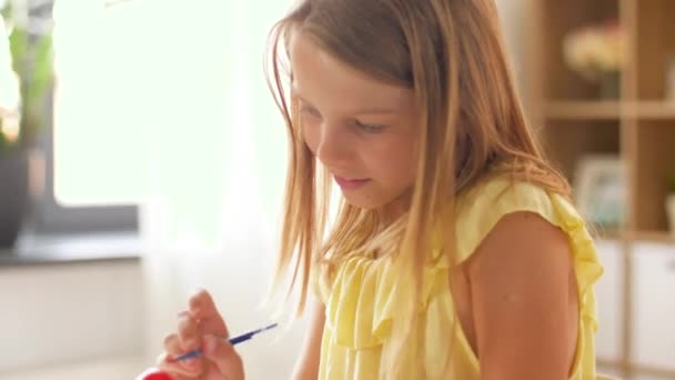 Glückliches Mädchen, das zu Hause Ostereier färbt — Stockvideo