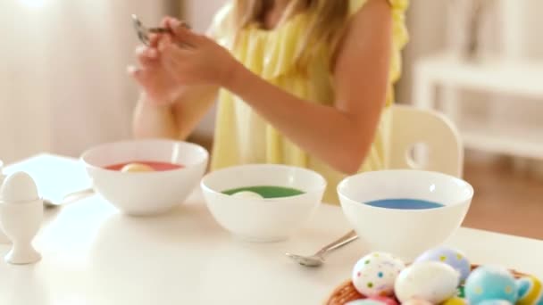 Girl coloring easter eggs by liquid dye at home — Stock Video