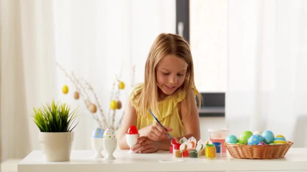 Menina feliz colorir ovos de Páscoa em casa — Vídeo de Stock