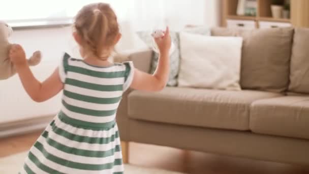 Девочка играет с мягким игрушечным кроликом и мышью — стоковое видео