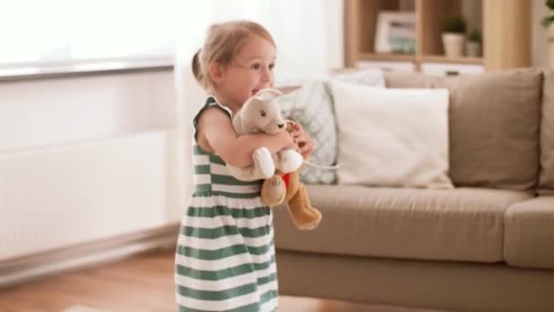Счастливая девочка играет с мягкими игрушками дома — стоковое видео