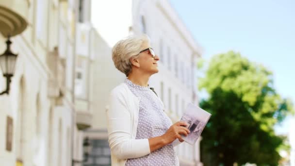 Senior woman or tourist with city guide on street — Stock Video