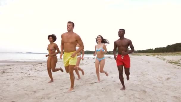 Amigos felices corriendo en la playa de verano — Vídeo de stock