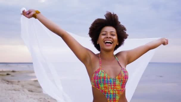 Afrikanerin mit Schal weht im Wind am Strand — Stockvideo