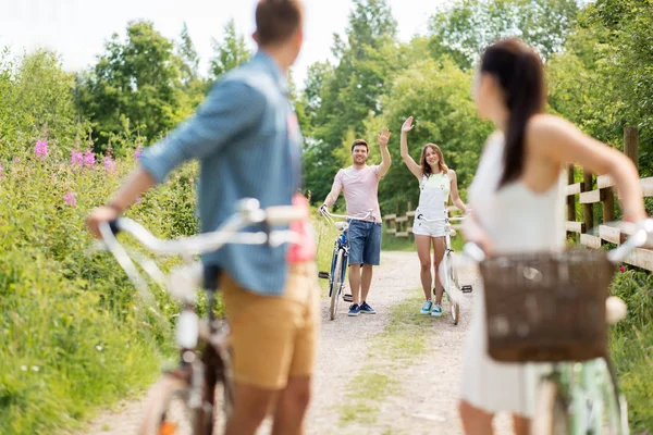 Glada vänner med fasta redskap cyklar i sommar — Stockfoto