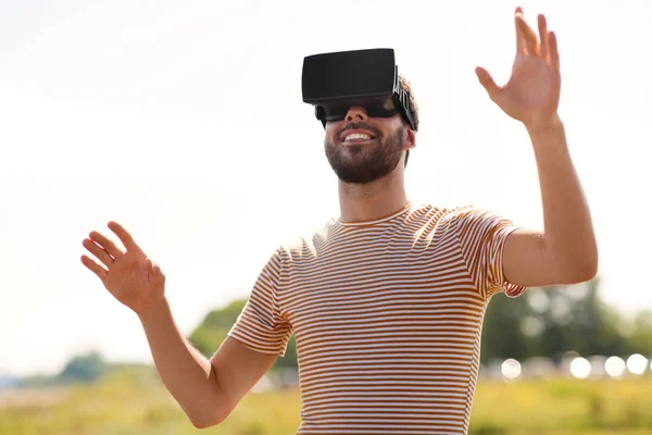 Улыбающийся человек в гарнитуре виртуальной реальности на открытом воздухе — стоковое фото