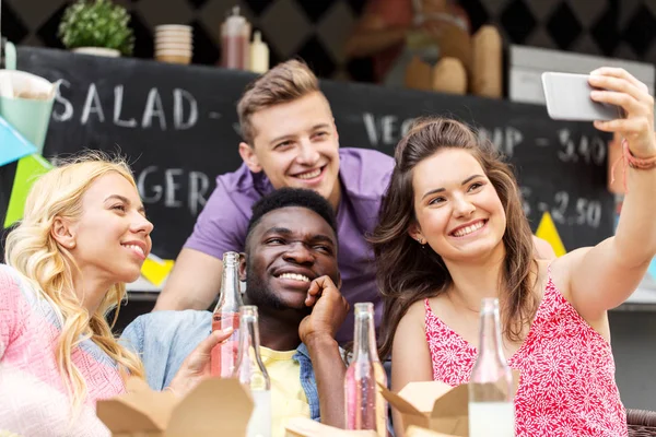 Jovens amigos felizes tomando selfie no caminhão de comida — Fotografia de Stock