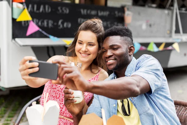 Smíšené rasy pár pořizování selfie v kamionu potravin — Stock fotografie