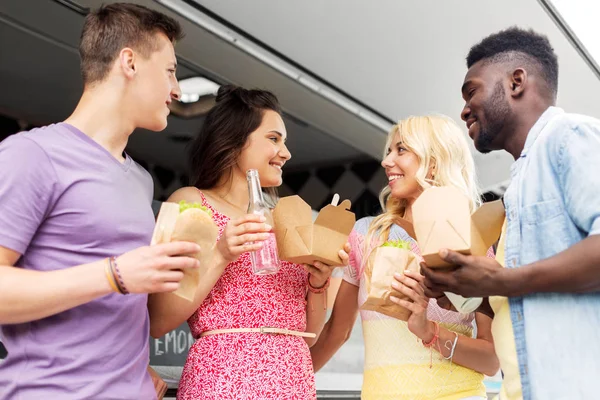 Щасливі друзі з напоями, що їдять у харчовій машині — стокове фото