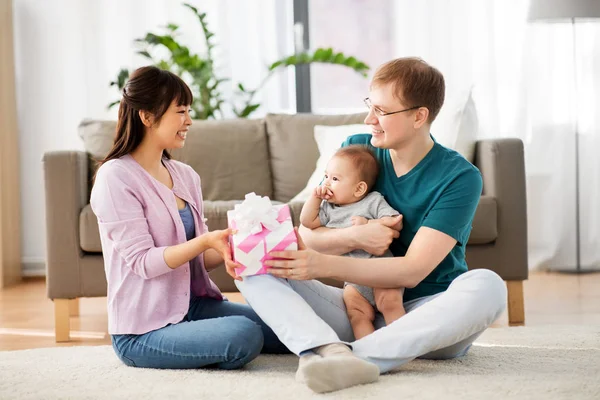 Família feliz com presente e menino em casa — Fotografia de Stock