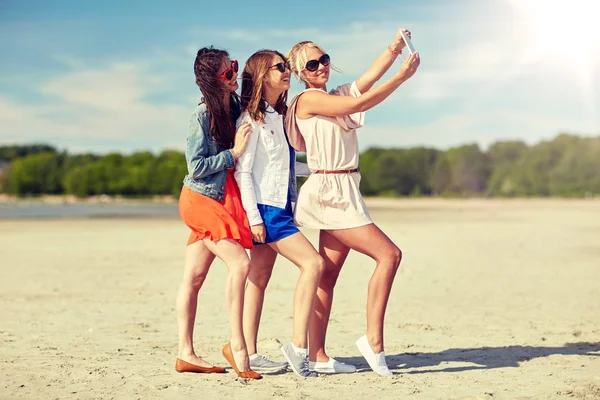 Grupp av leende kvinnor som tar selfie på stranden — Stockfoto