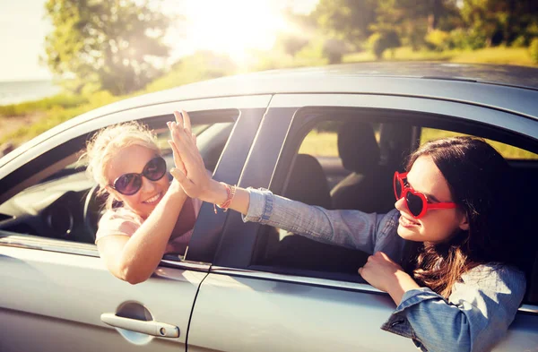 Meninas adolescentes felizes ou mulheres no carro à beira-mar — Fotografia de Stock