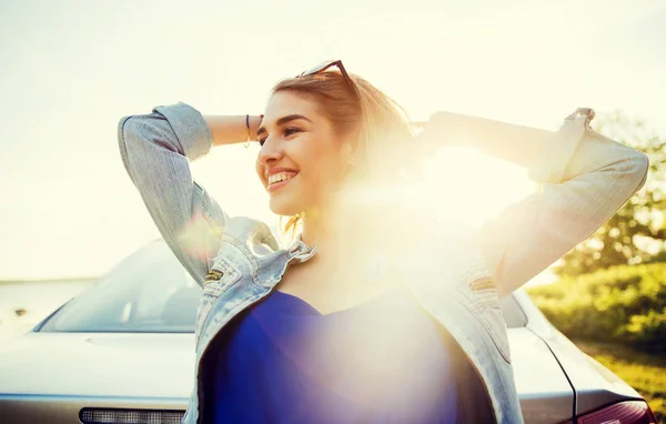 Счастливая девушка-подросток или молодая женщина возле автомобиля — стоковое фото