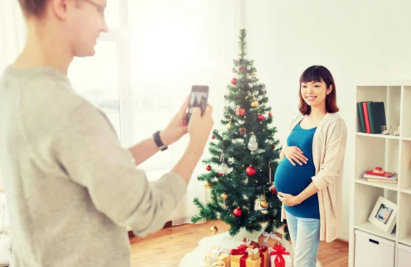 Marido fotografiando embarazada fife en Navidad — Foto de Stock