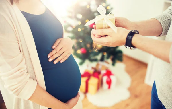 Echtgenoot van geven kerstcadeau aan zwangere vrouw — Stockfoto